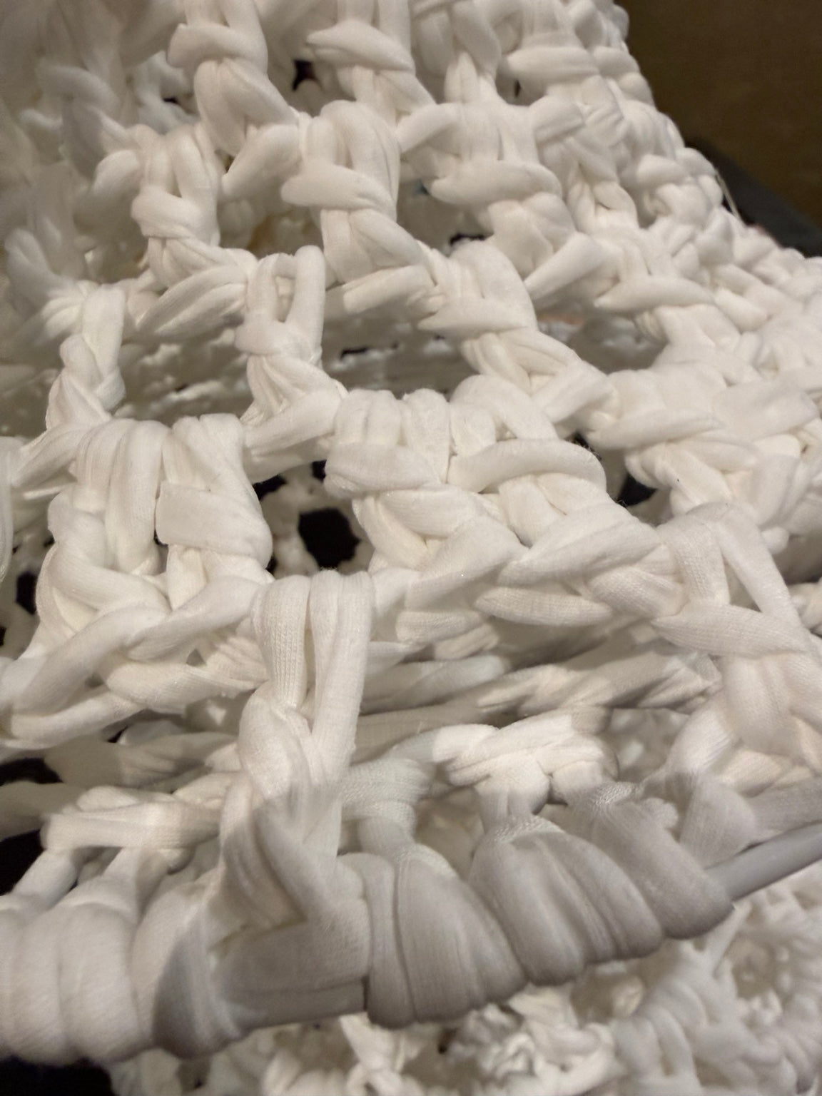 Detail van het witte haakwerk van gerecyclede vezels