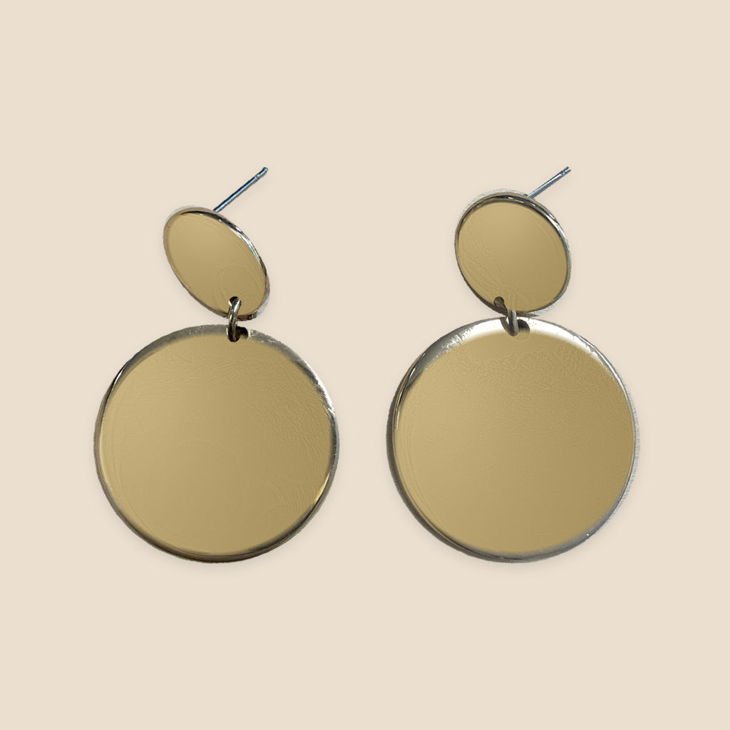 Golden Circles goudkleurige oorbellen op warm beige achtergrond