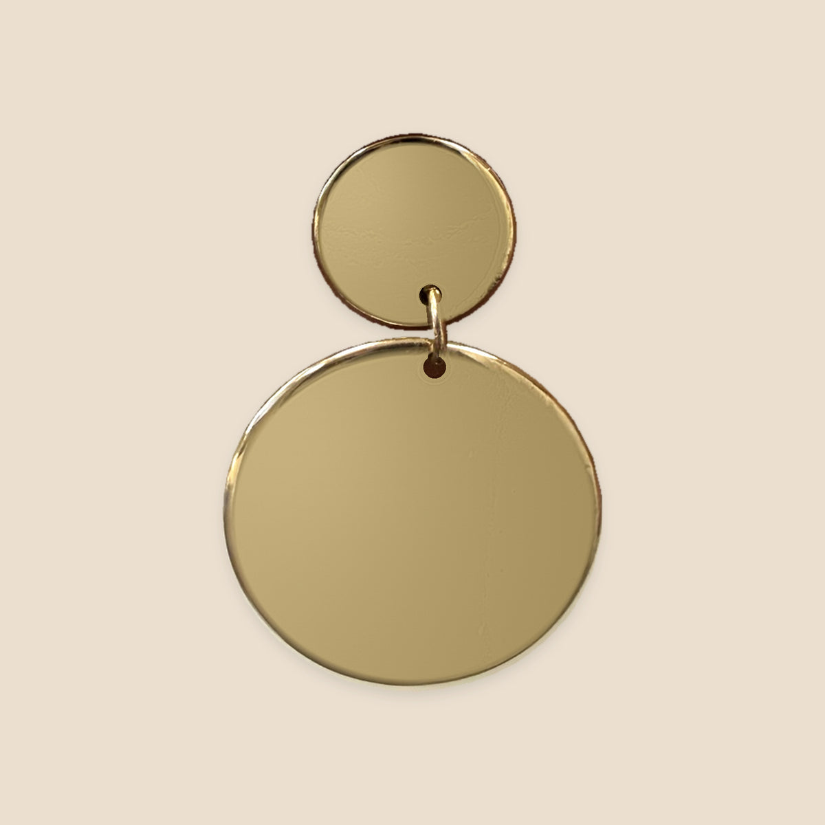 Golden Circles goudkleurige oorbellen op warm beige achtergrond