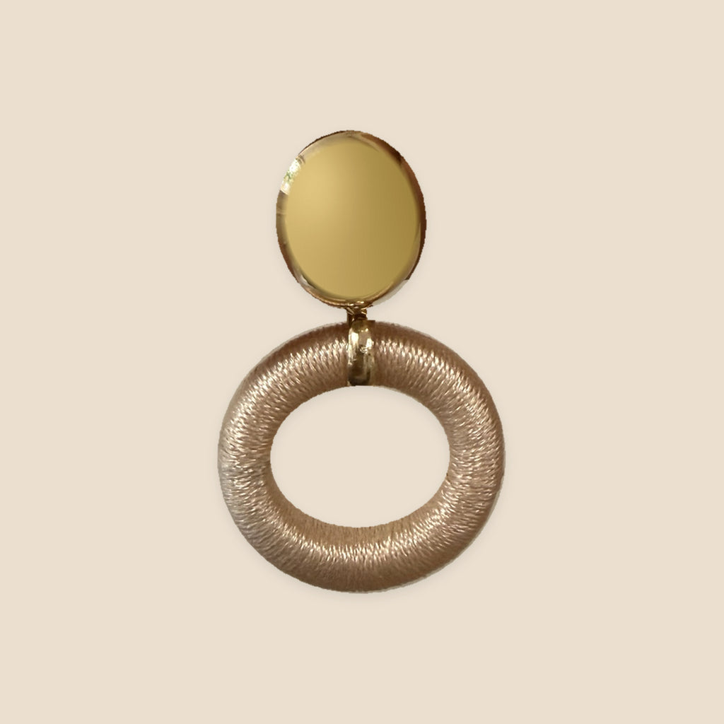 Satin Halo champagnekleurige oorbel met goudkleurig ovaal knopje op warm beige