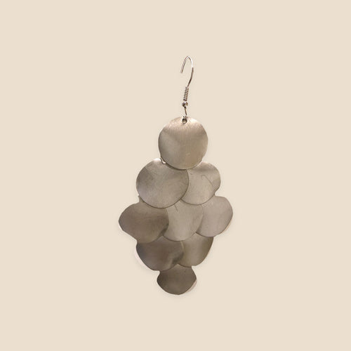 Silver Cascade zilverkleurige oorbel met overlappende ronde schijfjes op warm beige